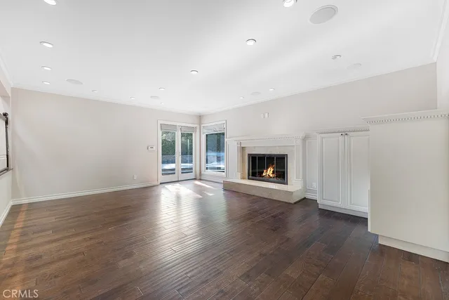 an empty room with wooden floor and fireplace