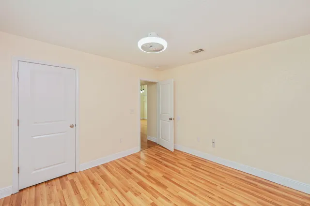 a view of empty room with wooden floor