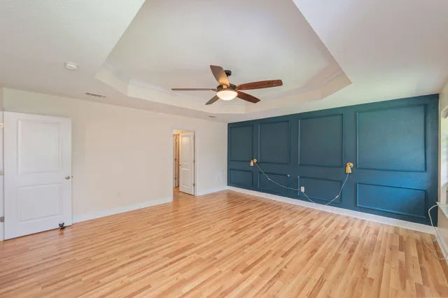 a view of a room with cabinet a ceiling fan and hardwood floor