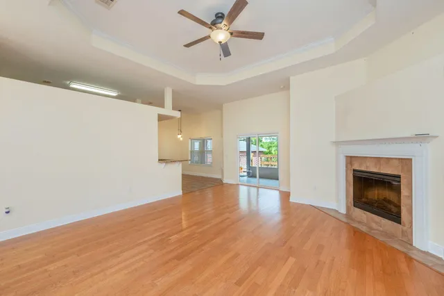 a view of empty room with wooden floor fireplace and a window