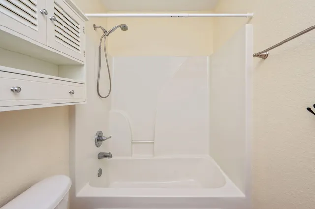 a bathroom with a bath tub with a shower