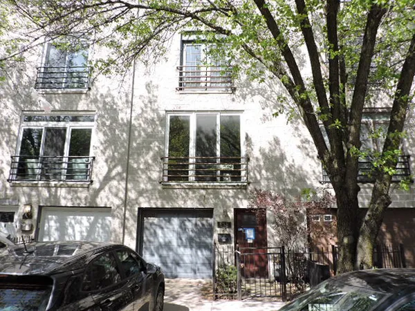 a front view of a house with a tree