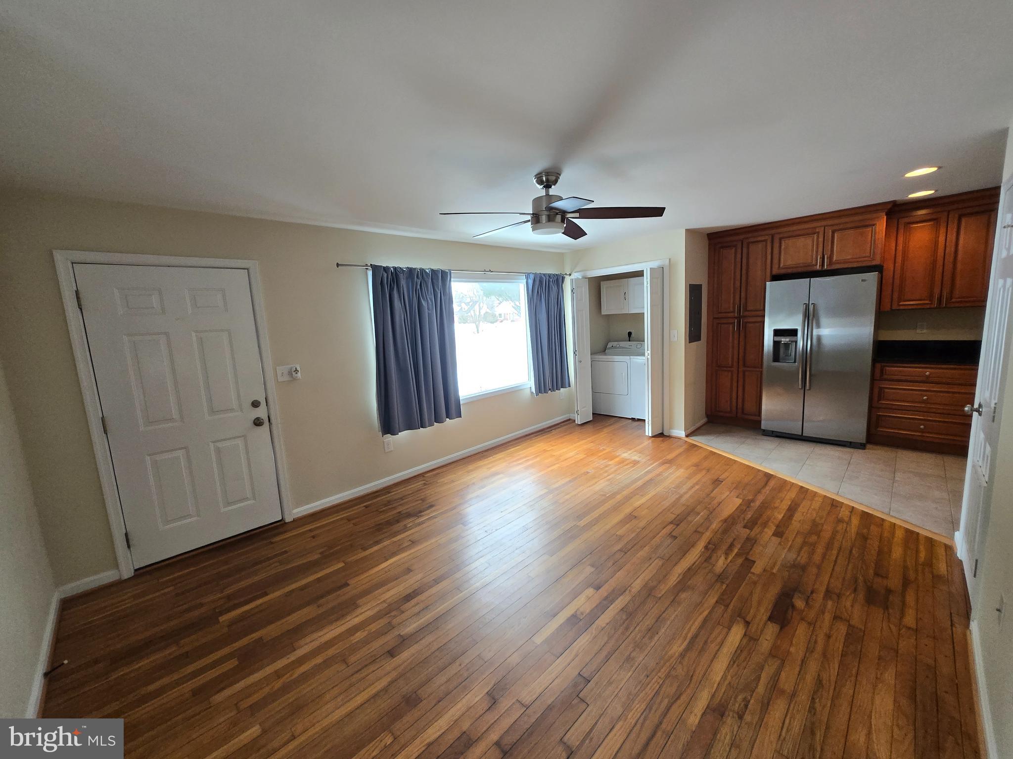 a view of a livingroom with wooden floor and staircase