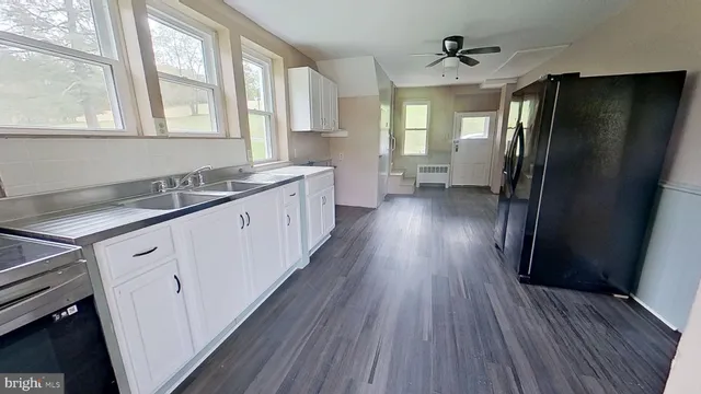 a kitchen with a sink a refrigerator a stove and cabinets