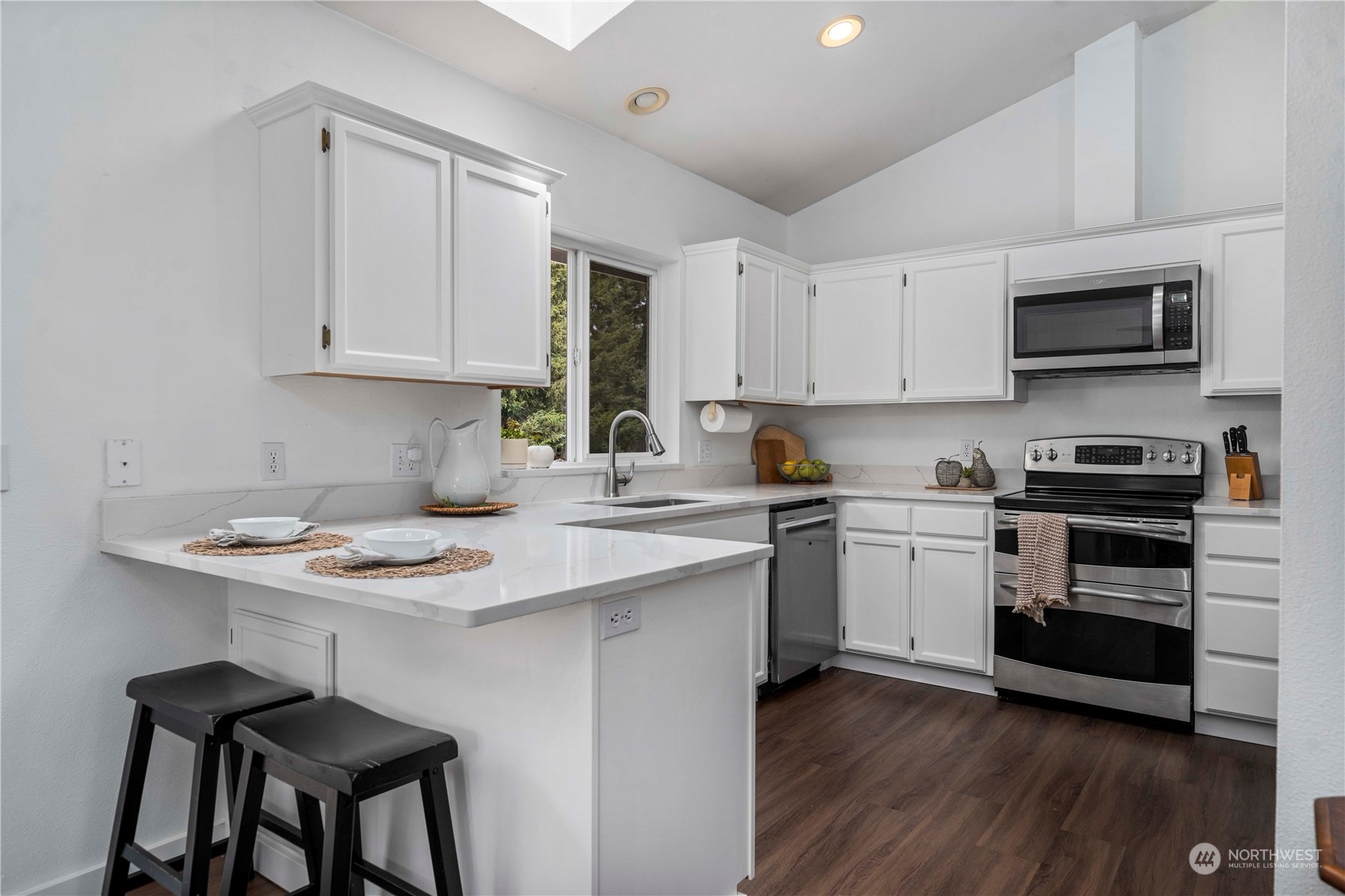 22716 Southeast 264th Place Maple Valley, WA 98038 - Photo 12 of 28 a kitchen with stainless steel appliances a sink a stove top oven a counter space and cabinets