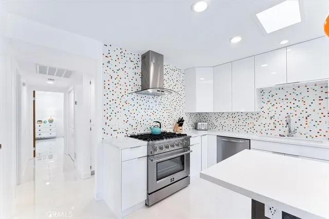 a kitchen with white cabinets and appliances