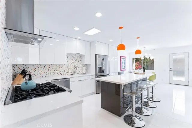 a kitchen with a sink a stove and chairs