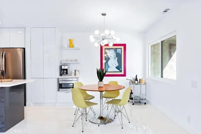 a dining room with wooden floor a chandelier a wooden table and chairs