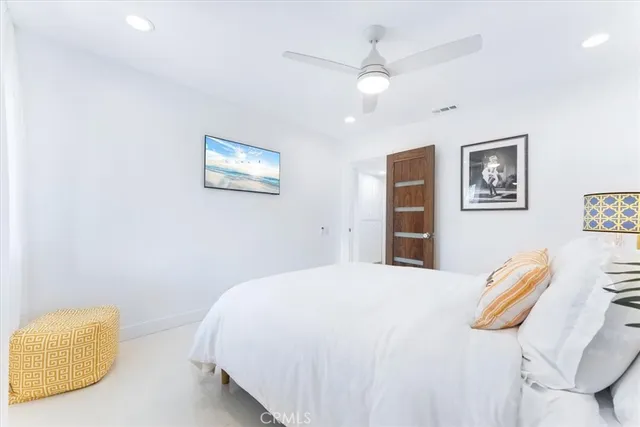 a bedroom with a bed and a painting on the wall