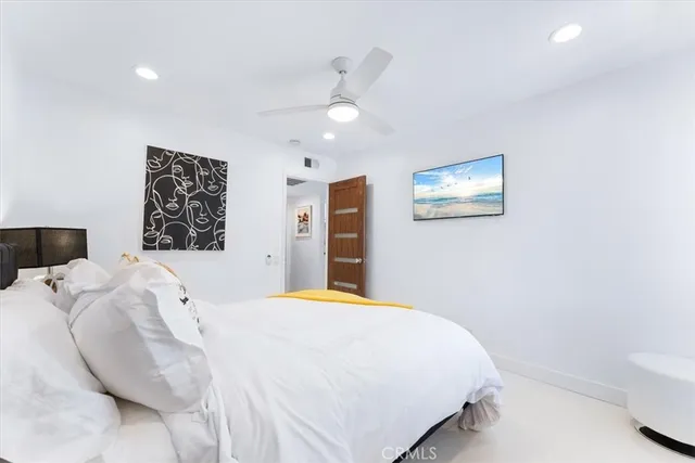 a bedroom with a bed and a painting on the wall