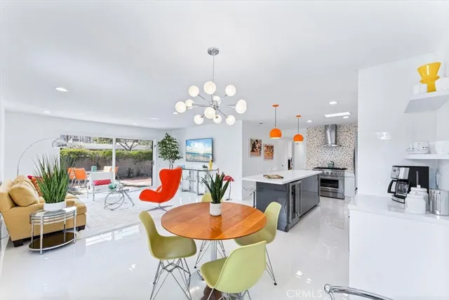 a living room with dining table and a chandelier