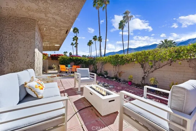 a view of a patio with couches table and chairs with potted plants