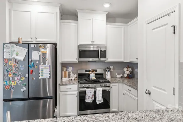 a kitchen with stainless steel appliances granite countertop a refrigerator sink and stove