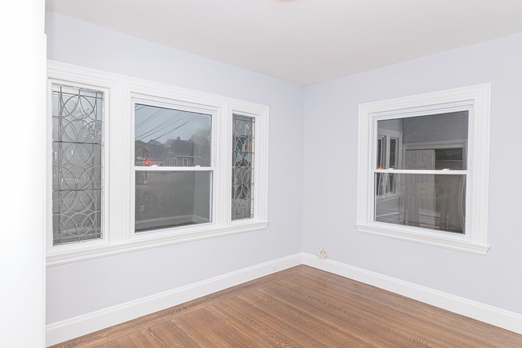232 Aspinwall Avenue, Unit 1 Brookline, MA 02445 - Photo 11 of 13 a view of an empty room with wooden floor and a window