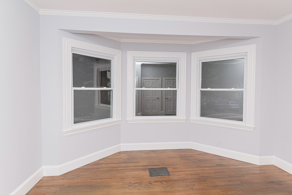 232 Aspinwall Avenue, Unit 1 Brookline, MA 02445 - Photo 10 of 13 a view of an empty room with wooden floor and a window