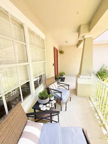 a living room with furniture a rug and a floor to ceiling window