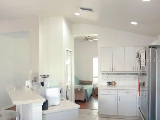 a kitchen with white cabinets and sink