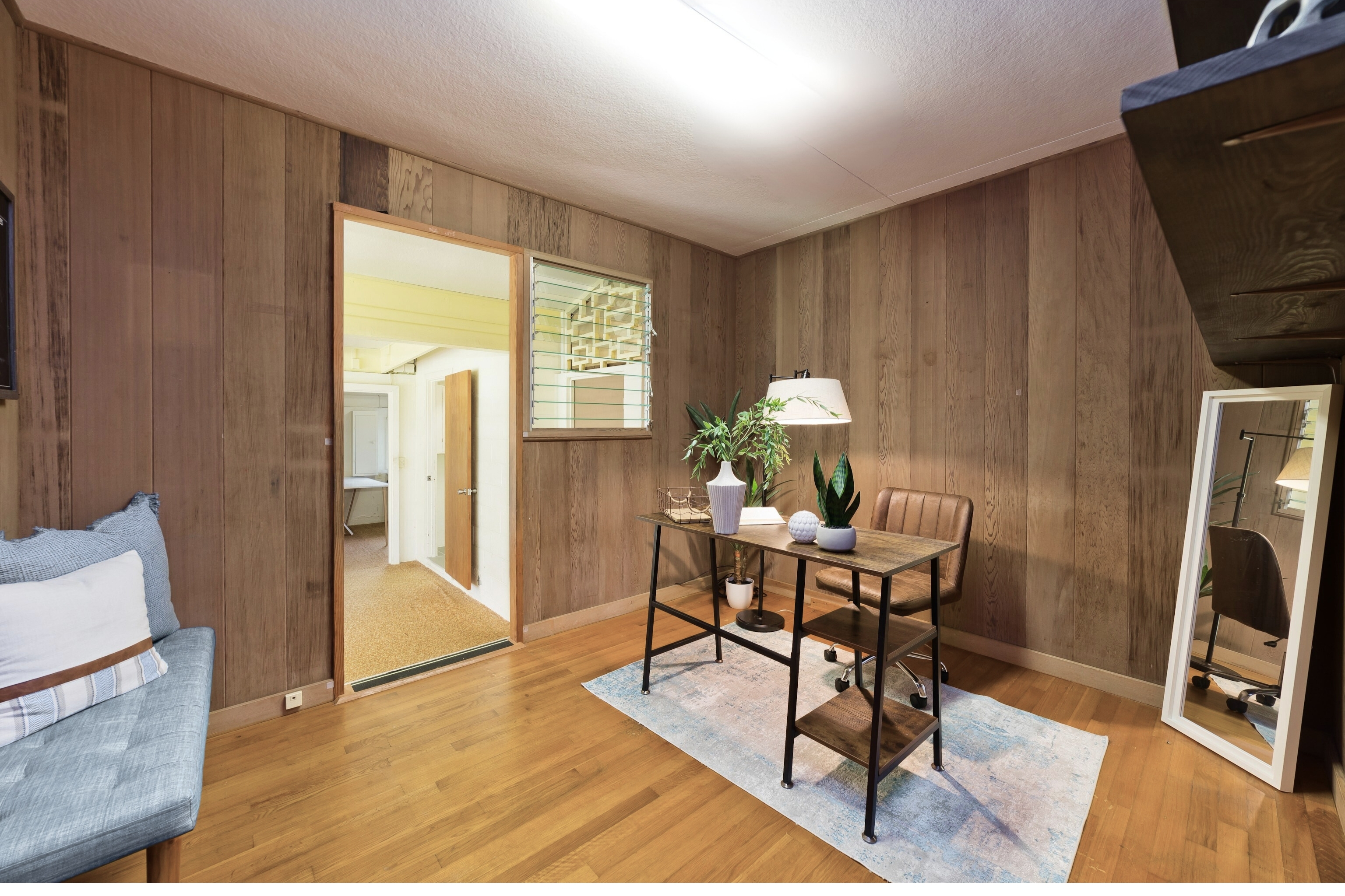 25 Wawai Loop Hilo, HI 96720 - Photo 12 of 22 a work room with furniture a rug and a flat screen tv