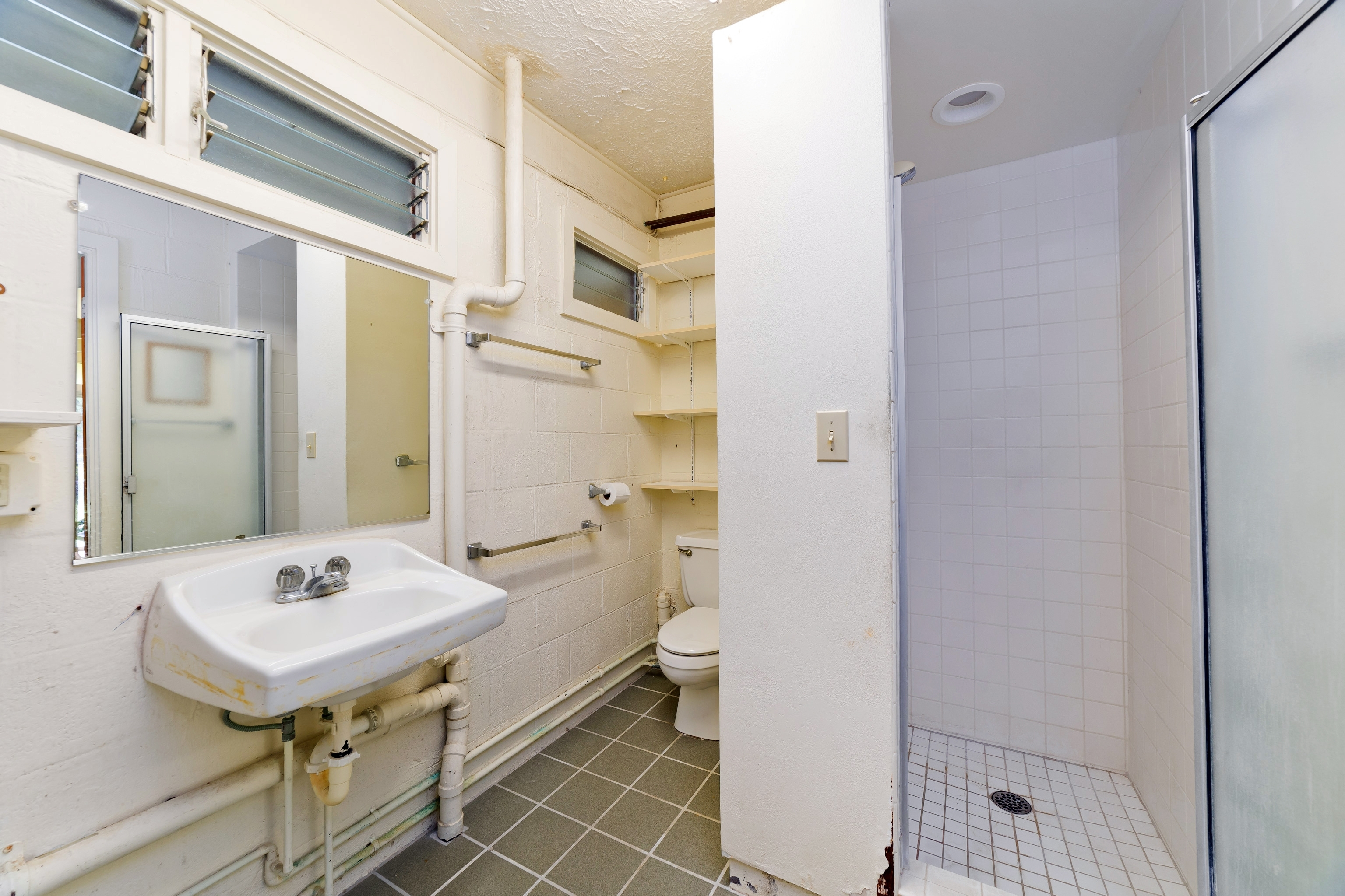 25 Wawai Loop Hilo, HI 96720 - Photo 16 of 22 a bathroom with a sink a toilet and shower