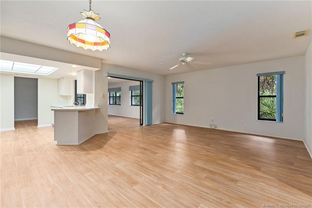 542 Woods Edge Trail Stuart, FL 34997 - Photo 11 of 31 a view of a kitchen with wooden floor and a ceiling fan