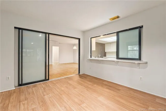a view of empty room with wooden floor and fan