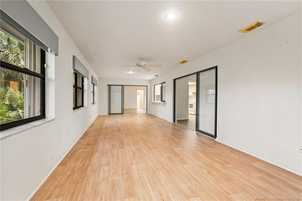 542 Woods Edge Trail Stuart, FL 34997 - Photo 13 of 31 a view of an empty room with wooden floor and a window