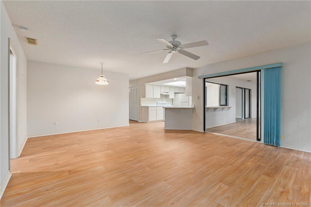 542 Woods Edge Trail Stuart, FL 34997 - Photo 16 of 31 a view of a big room with wooden floor and windows
