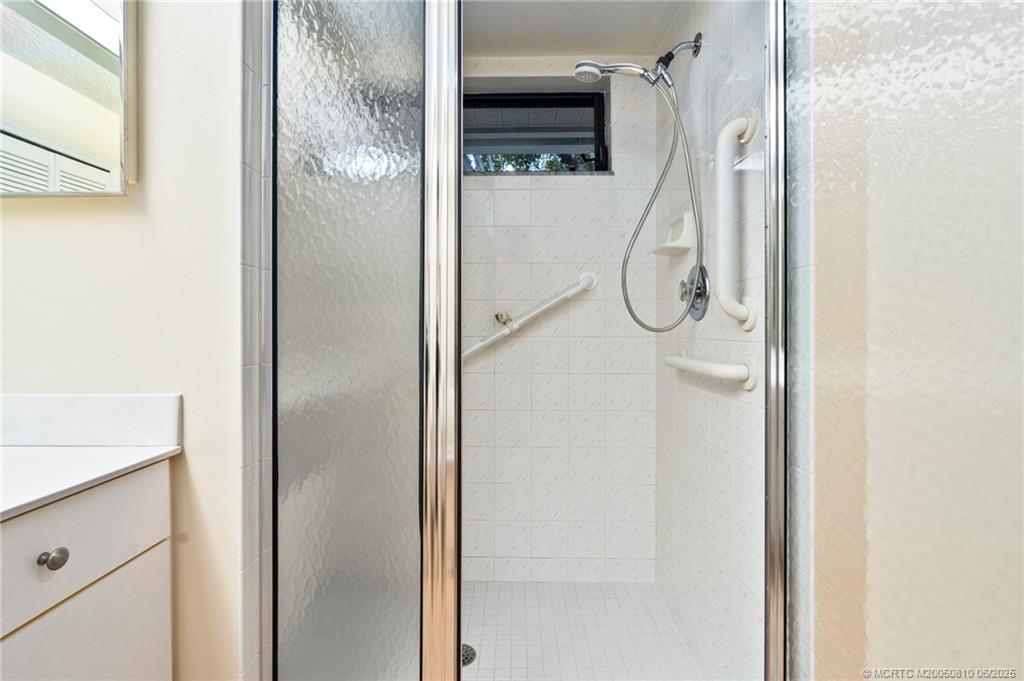 542 Woods Edge Trail Stuart, FL 34997 - Photo 21 of 31 a bathroom with a glass shower door