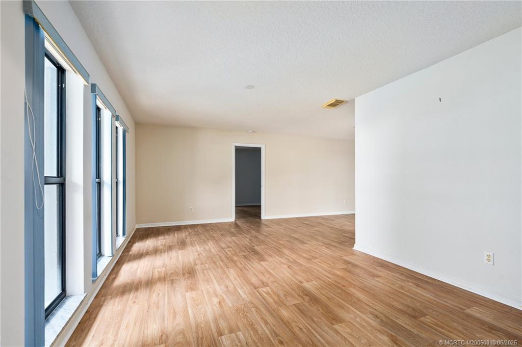 542 Woods Edge Trail Stuart, FL 34997 - Photo 3 of 31 a view of an empty room with wooden floor