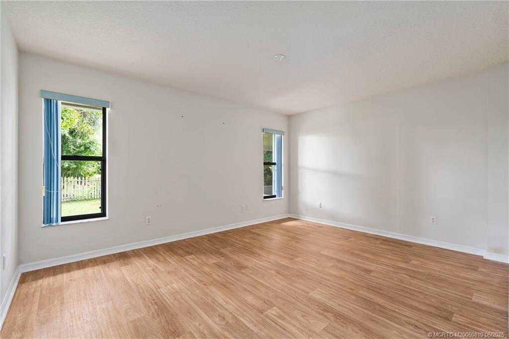 542 Woods Edge Trail Stuart, FL 34997 - Photo 5 of 31 a view of an empty room with wooden floor and a window