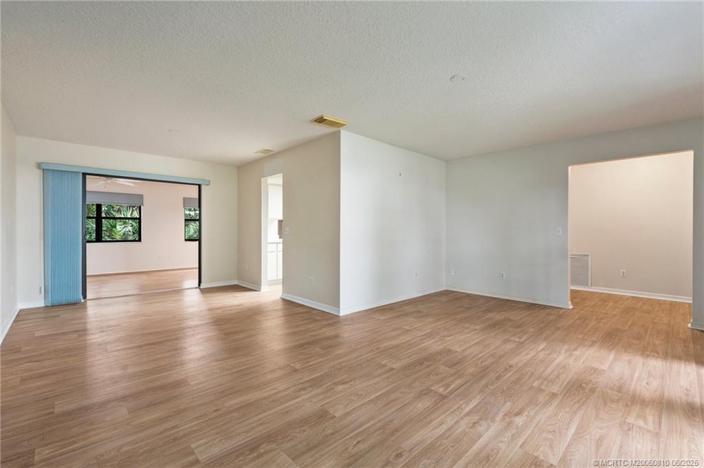 542 Woods Edge Trail Stuart, FL 34997 - Photo 6 of 31 a view of an empty room with wooden floor and a window