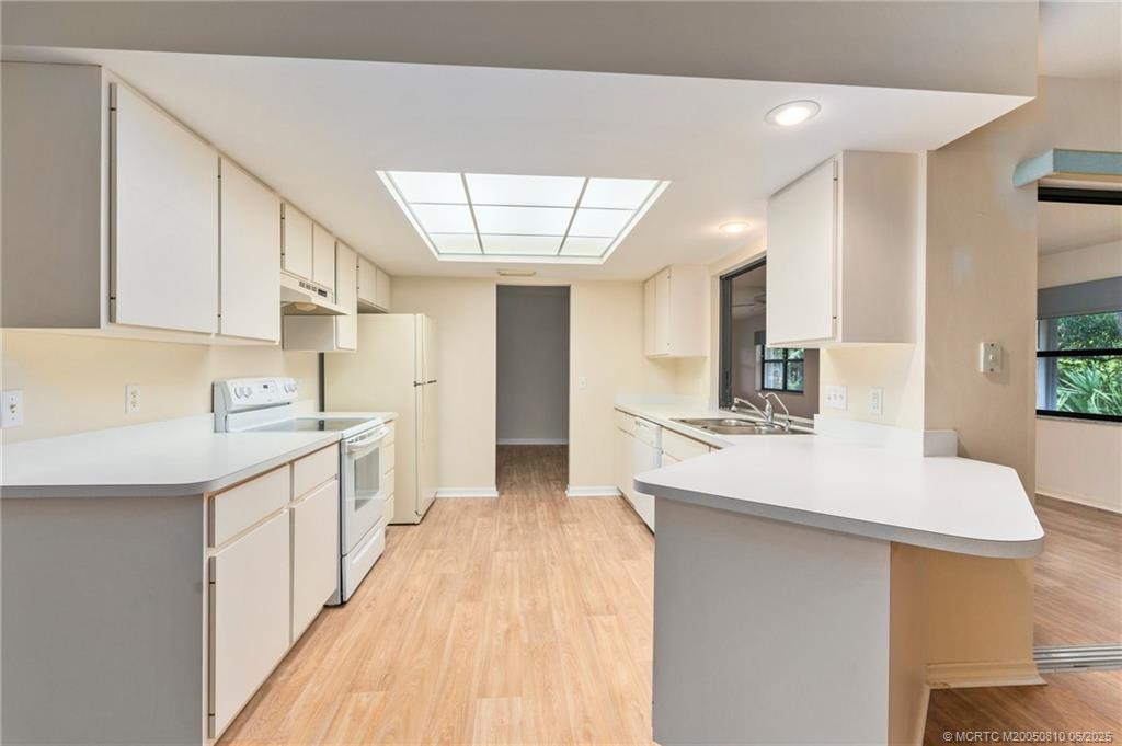 542 Woods Edge Trail Stuart, FL 34997 - Photo 8 of 31 a kitchen with a sink a stove a refrigerator and white cabinets
