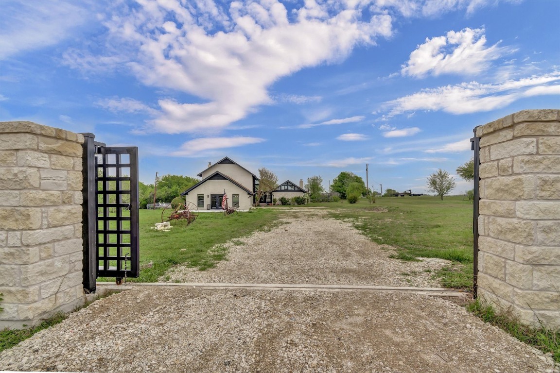 1201 County Road 138 Hutto, TX 78634 - Photo 1 of 26 a view of a brick house next to a yard with big trees