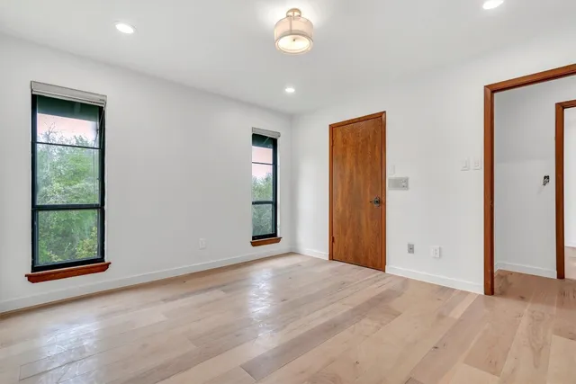 an empty room with windows and closet