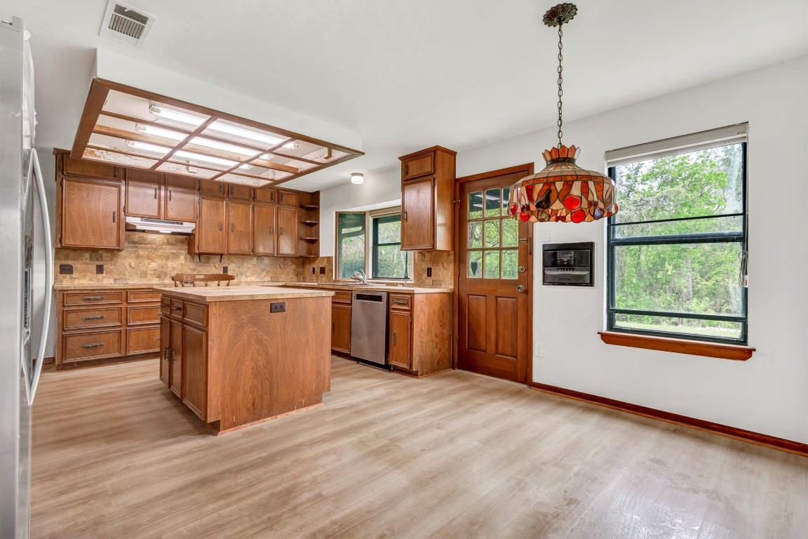 1201 County Road 138 Hutto, TX 78634 - Photo 5 of 26 a open kitchen with stainless steel appliances granite countertop a stove a sink dishwasher and a refrigerator with wooden floor