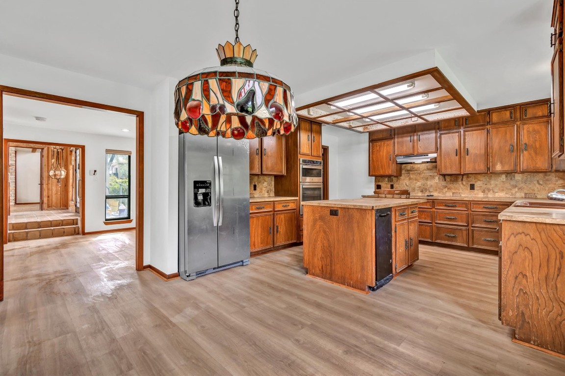 1201 County Road 138 Hutto, TX 78634 - Photo 8 of 26 a kitchen with stainless steel appliances granite countertop a refrigerator a sink a stove and a wooden floors