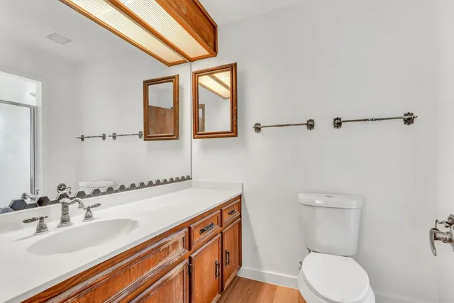a bathroom with a toilet a sink and mirror