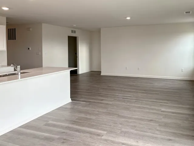 a view of a kitchen with wooden floor and a sink