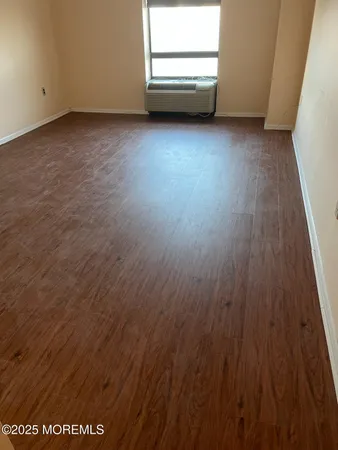 a view of a room with wooden floor and window