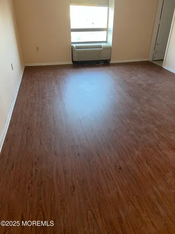 a view of a room with wooden floor and electronic appliances