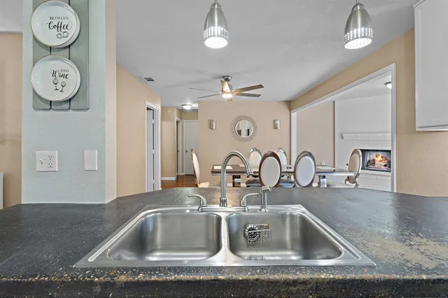 a close view of a sink a large mirror and vanity with clock on the wall