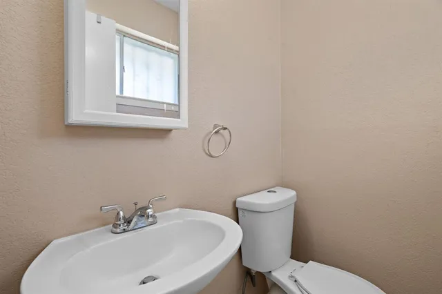a bathroom with a toilet sink and mirror