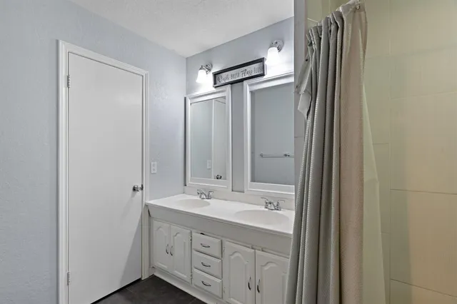 a bathroom with double vanity sink and mirror