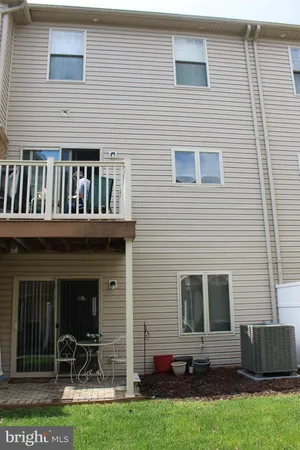 a view of backyard with seating space and wooden fence