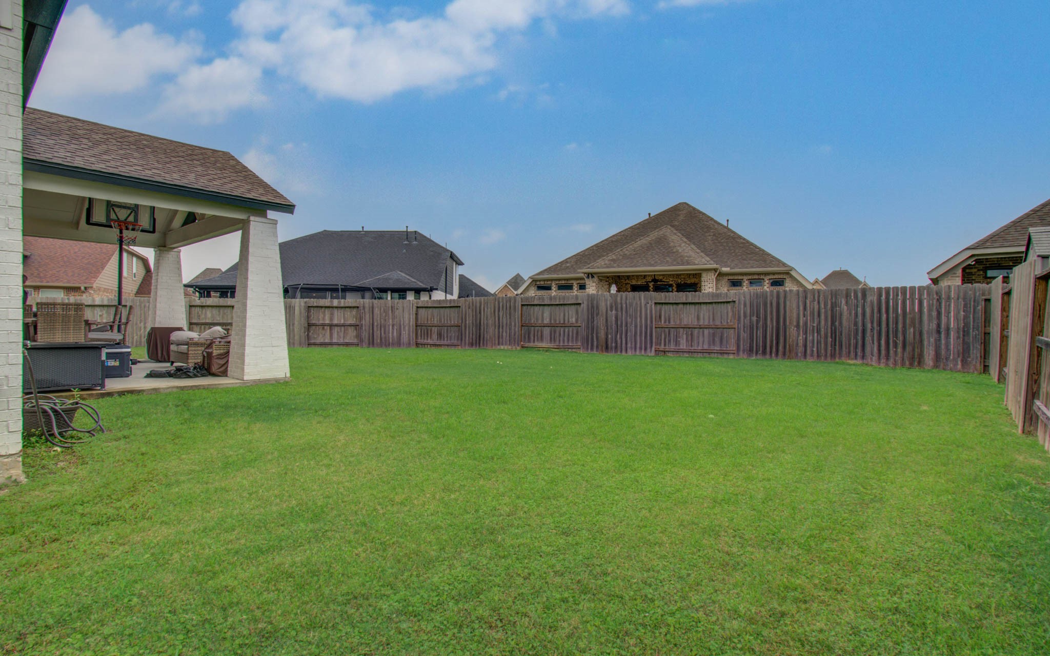 4211 Limestone Terrace Manvel, TX 77578 - Photo 31 of 33 Spacious backyard with a well-maintained lawn, privacy fence, and a covered patio area ideal for outdoor activities and relaxation.