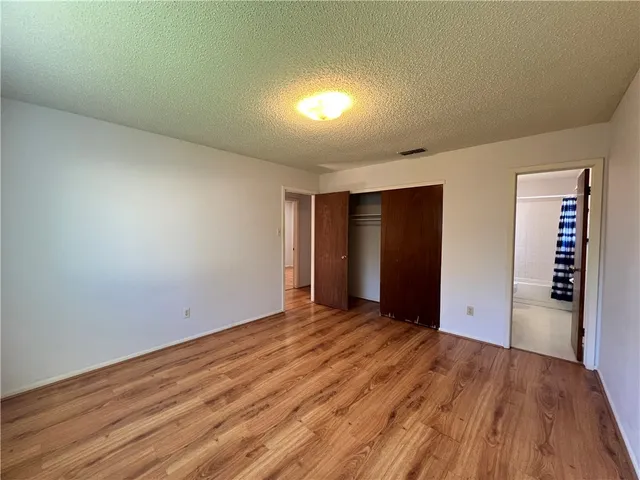 a view of an empty room with wooden floor and entryway