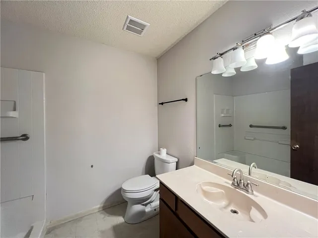 a bathroom with a sink vanity mirror and toilet