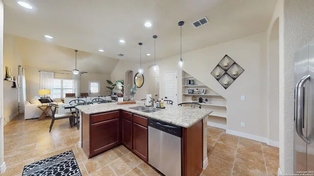 a kitchen with a sink a counter and chairs