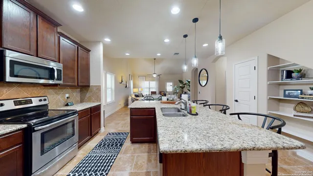 a kitchen with stainless steel appliances granite countertop a sink stove and cabinets