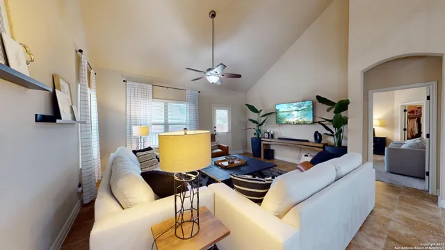 a living room with furniture a flat screen tv and kitchen view